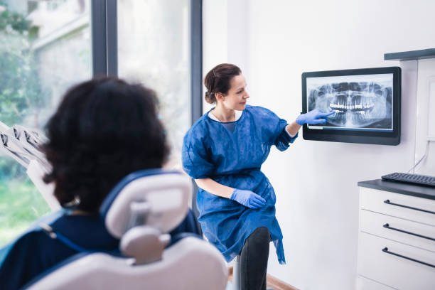 dentiste qui presente une radio a son client