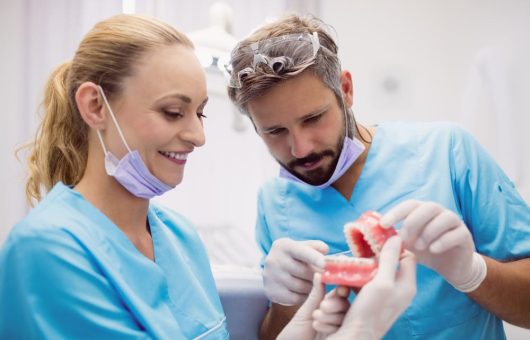 Chirurgiens dentaires avec une prothèse dentaire