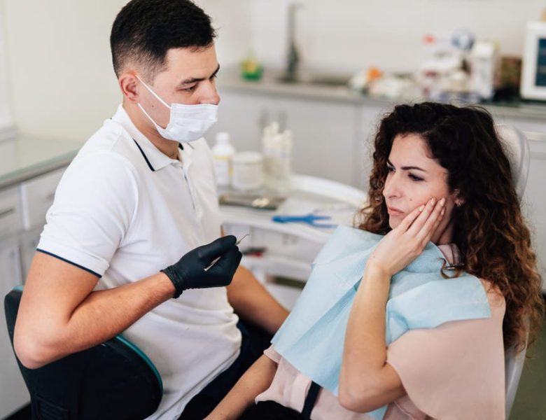 femme qui ressent une sensibilité dentaire