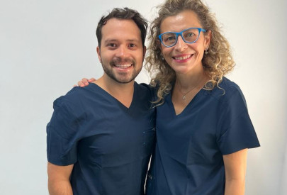Dentiste français a l'étranger souriant tenant des instruments dentaires et une brosse à dents, prêt pour un examen oral.