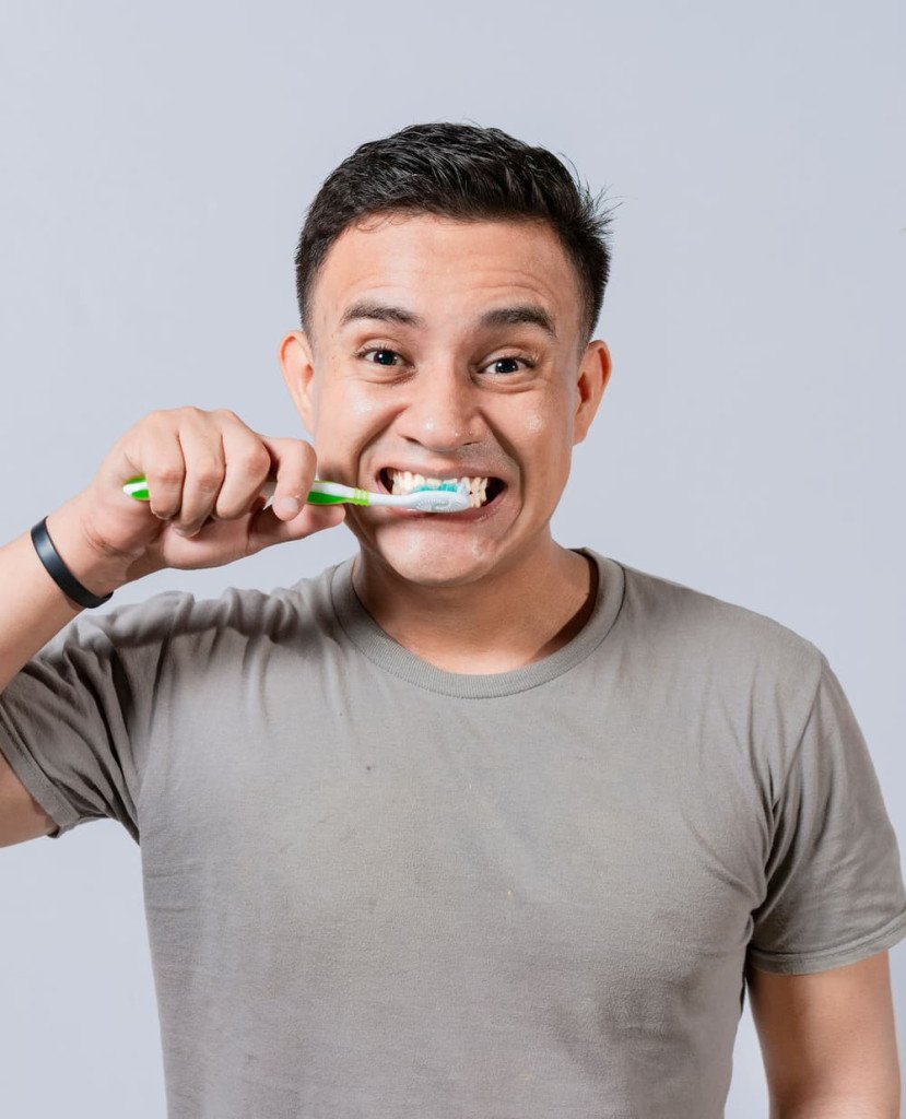 Homme brossant ses dents pour illustrer l'affaiblissement de l'émail dentaire.