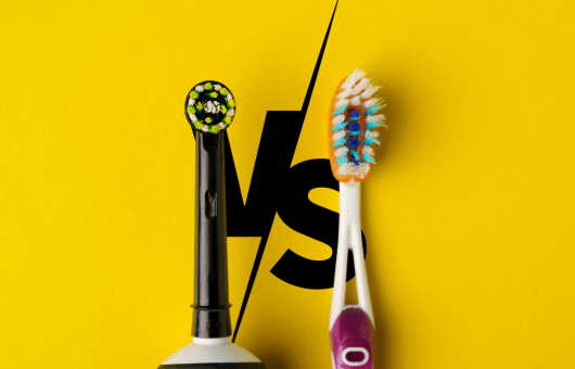 Comparaison entre une brosse à dents électrique et une brosse à dents manuelle sur fond jaune avec un 'VS' en arrière-plan.