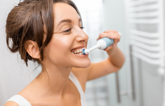 femme qui prends soin de ses dents pour éviter d'avoir une parodontite