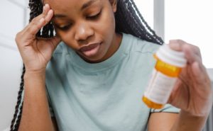 femme qui tient une boite de medicaments