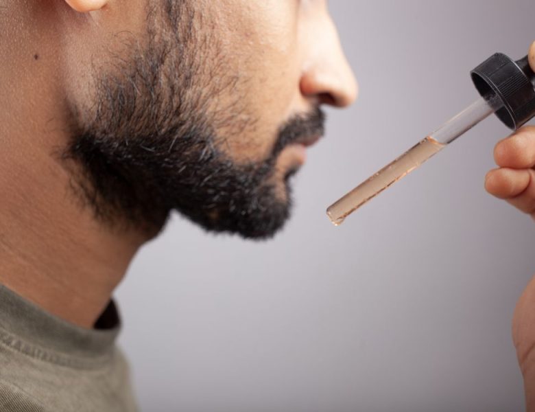 homme qui met du minoxidil pour faire pousser sa barbe