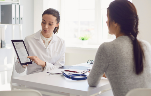 docteur qui montre un bilan dentaire à la patiente ménopausée