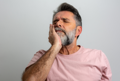 Homme qui a mal aux dents et a son implant