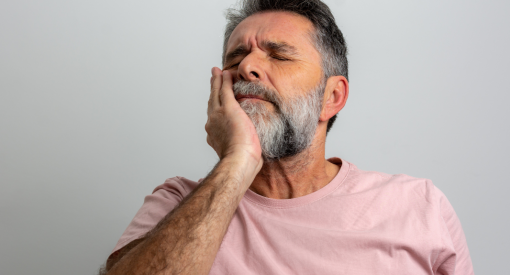 Homme qui a mal aux dents et a son implant
