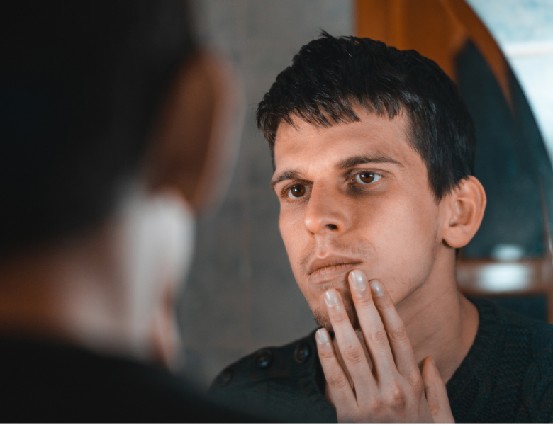 homme imberbe qui songe à la greffe de cheveux